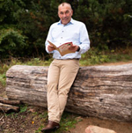 Trainer, Ingo Krawiec. liest Buch in der Natur – Symbol für Weiterbildung, Reflexion und persönliche Entwicklung im Training und Coaching.