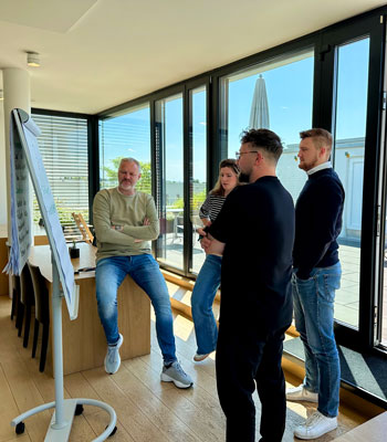 Train-the-Trainer-Grundkurs: Teilnehmende im Seminarraum diskutieren an einem Flipchart während einer praxisnahen Trainingssequenz